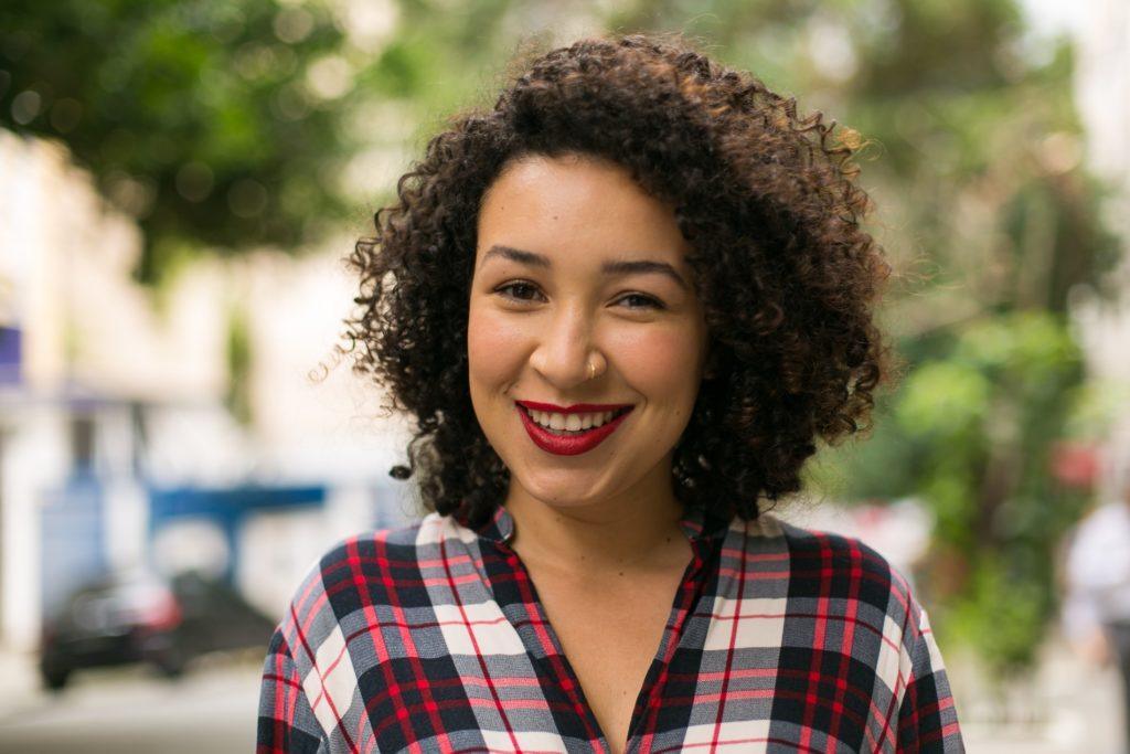 Mulher de cabelo curto encaracolado para matéria de produtos veganos Love Beauty and Planet