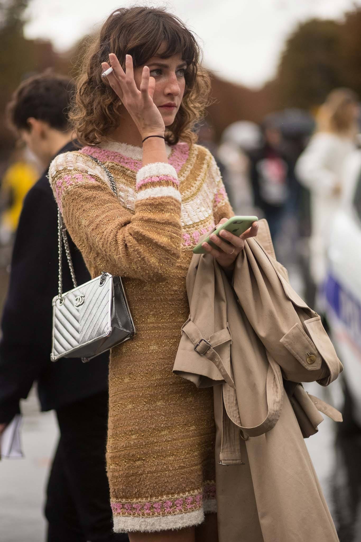 Mulher com cabelos médios fuma cigarro, prejudicial para os fios