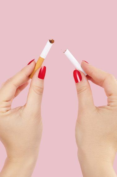 Mãos de uma mulher quebram o cigarro