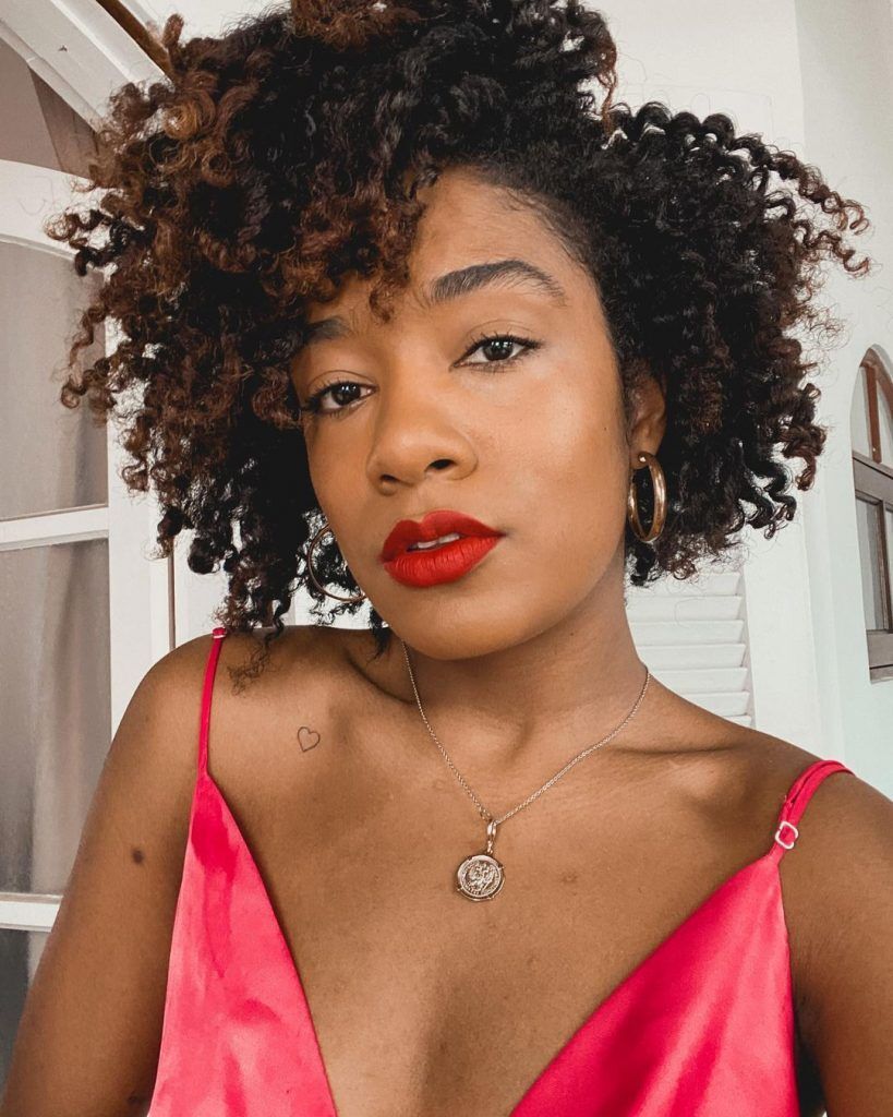 mulher negra com cabelo curto castanho cacheado