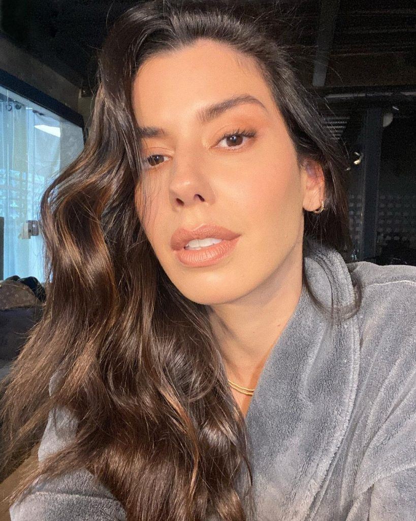 mulher branca com cabelo castanho ondulado