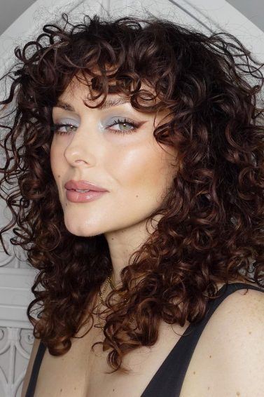 mulher com cabelo encaracolado com franja castanho