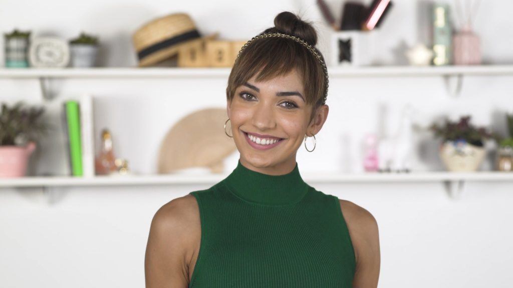 Modelo com cabelo preso em um coque e franja falsa