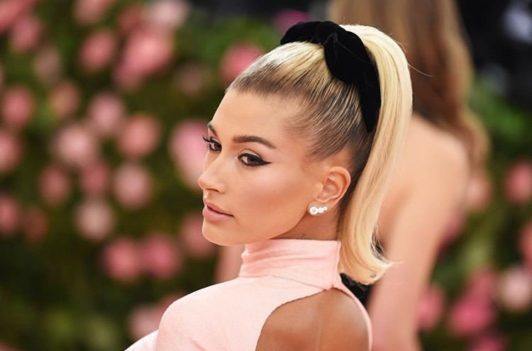 Penteado dos anos 60 com rabo de cavalo alto e laço