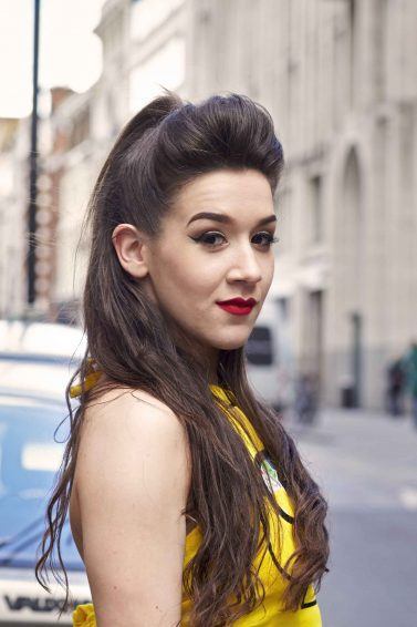 Modelo com cabelos longos e penteado semipreso com topete