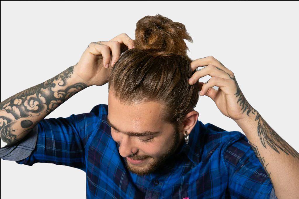 homem arrumando coque alto no cabelo