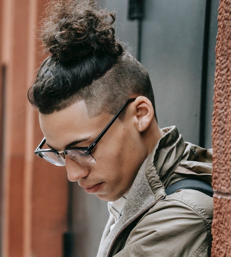 homem usa óculos e penteado man bun ou no cabelo undercut