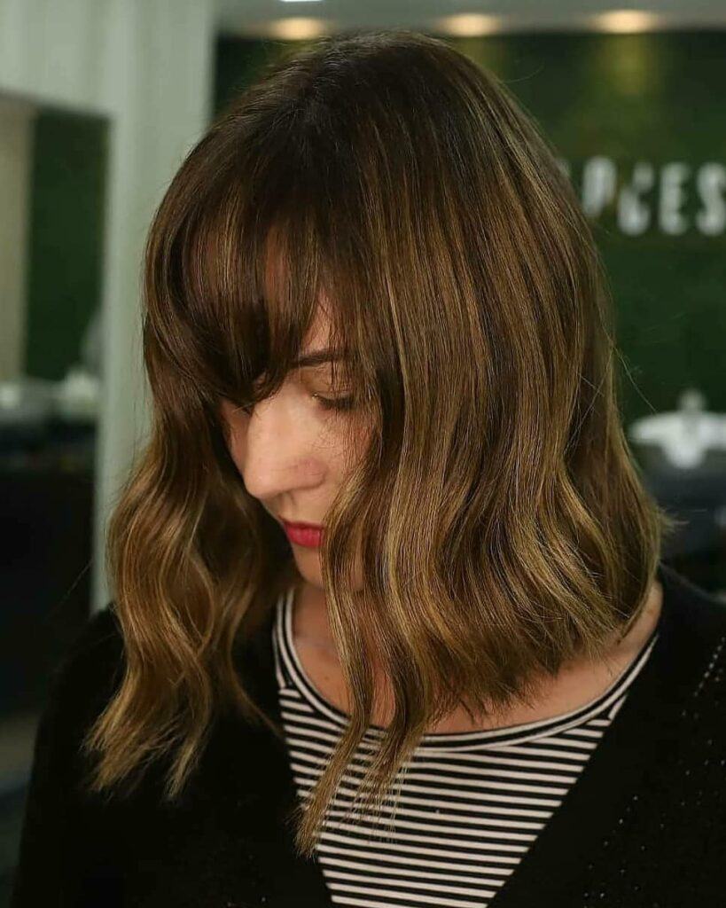 Mulher com cabelo chanel de bico e franja com reflexo castanho
