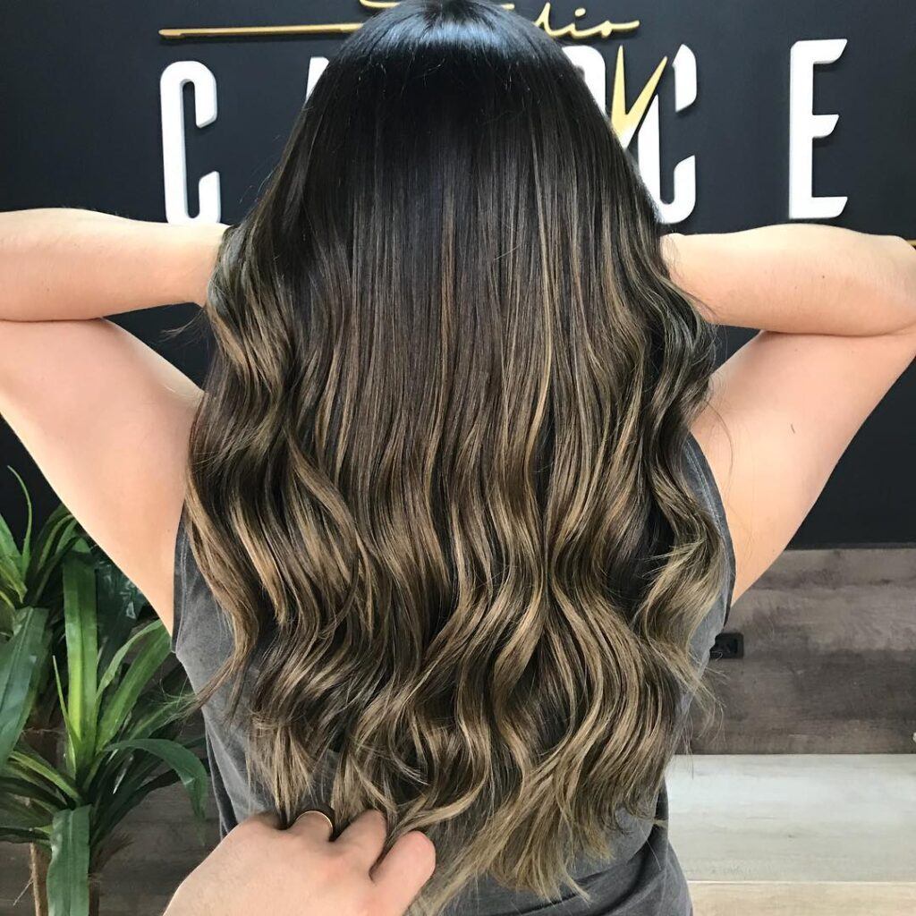 Mulher com reflexo champanhe no cabelo castanho escuro