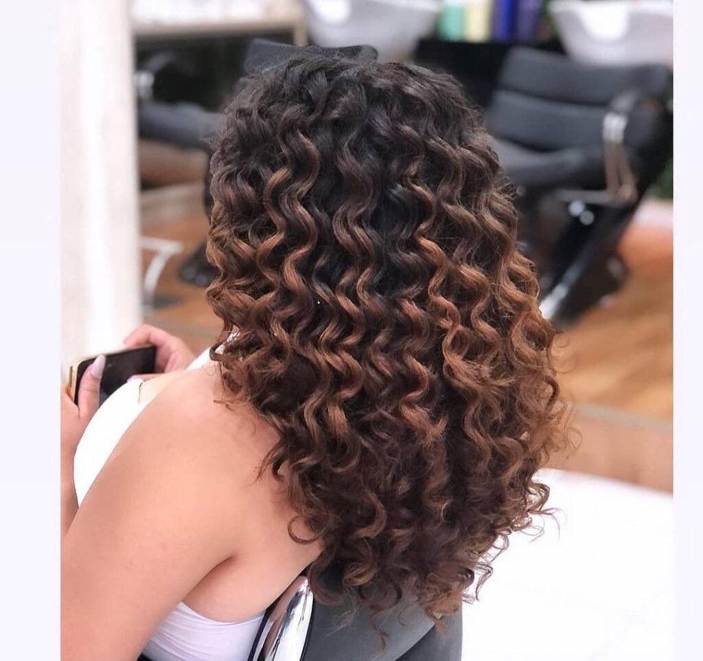 Mulher de cabelo cacheado com reflexo
