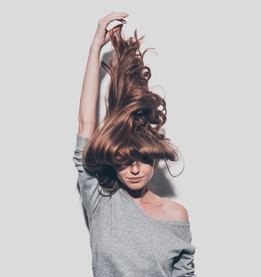 mulher puxando o cabelo longo pra cima