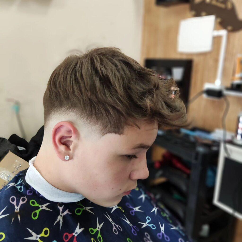 Homem virado de lado com o cabelo no estilo undercut shark