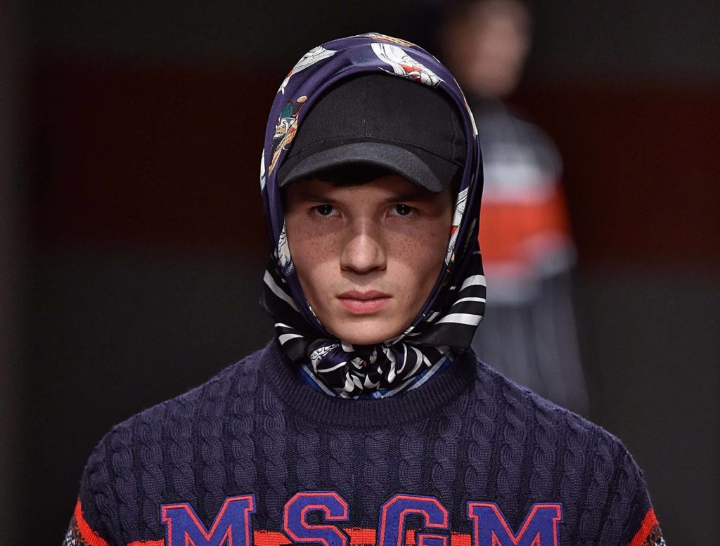 Modelo com boné para os cabelos das semanas de moda masculina