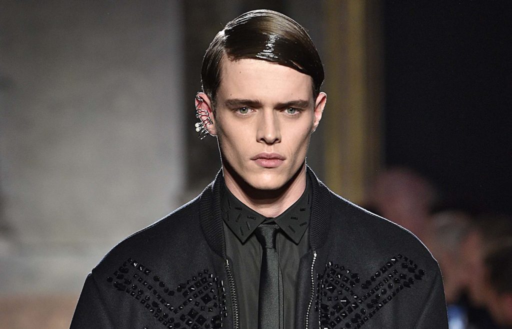 Homem com cabelo com risca lateral e gem para matéria de cabelos masculinos no tapete vermelho