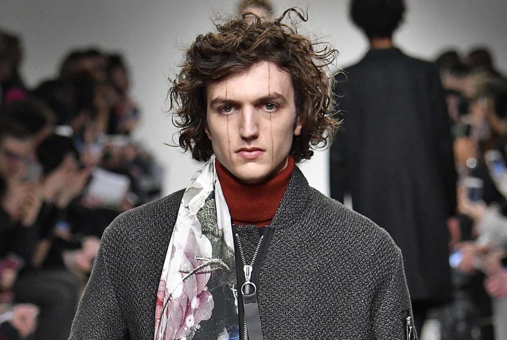 Homem com cabelo encaracolado para matéria de cabelos masculinos no tapete vermelho