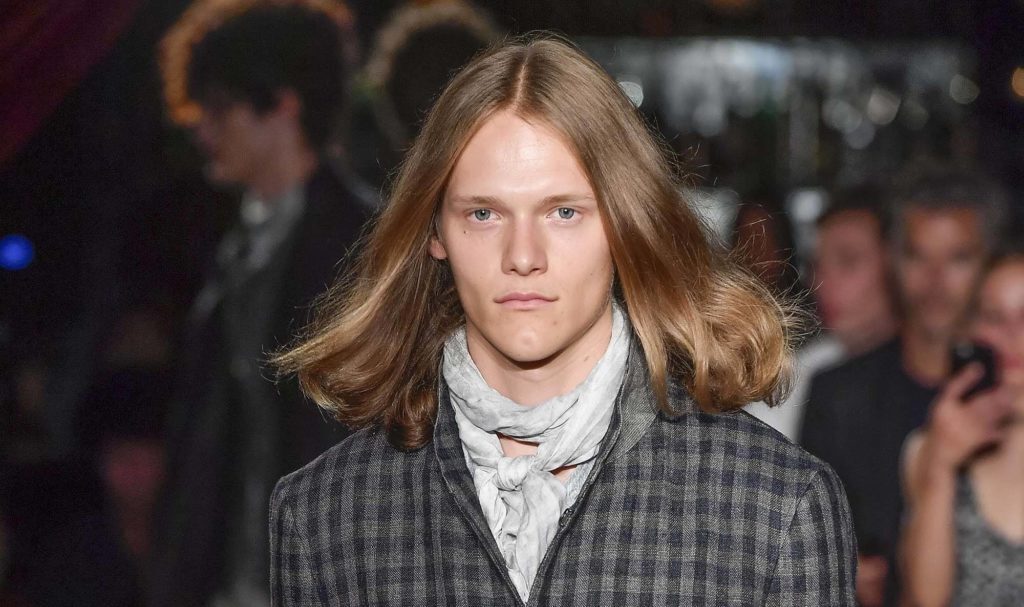 Homem com cabelo loiro comprido para matéria de cabelos masculinos no tapete vermelho