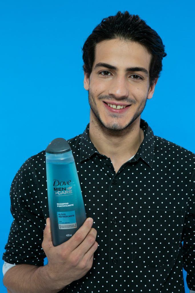 Modelo masculino segurando o ove Men+Care Shampoo Alívio Refrescante