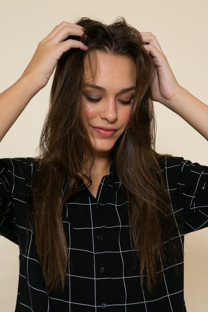 Modelo massageia o couro cabeludo para estilizar o cabelo com shampoo seco