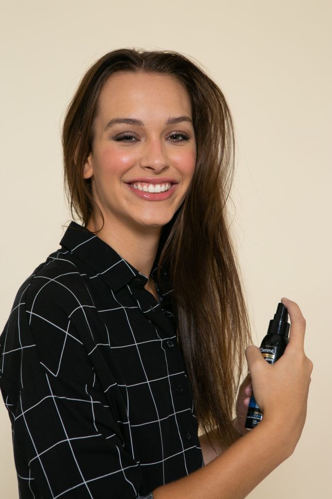 Modelo aplica spray para revitalizar os fios