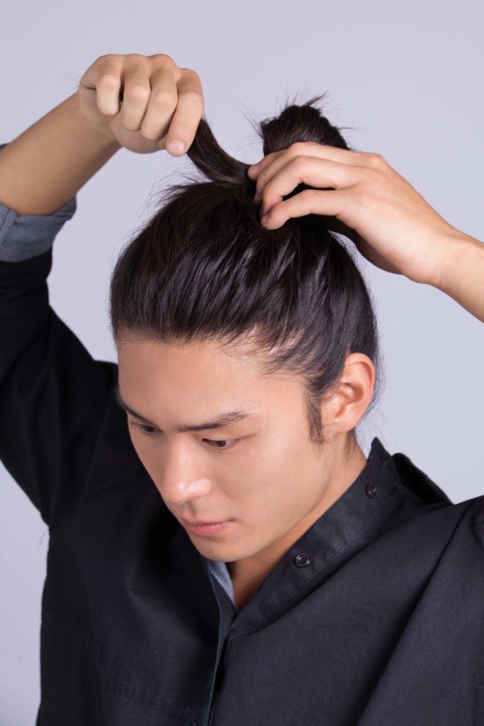 Modelo mostra o terceiro passo de como fazer cabelo masculino com ondas:
