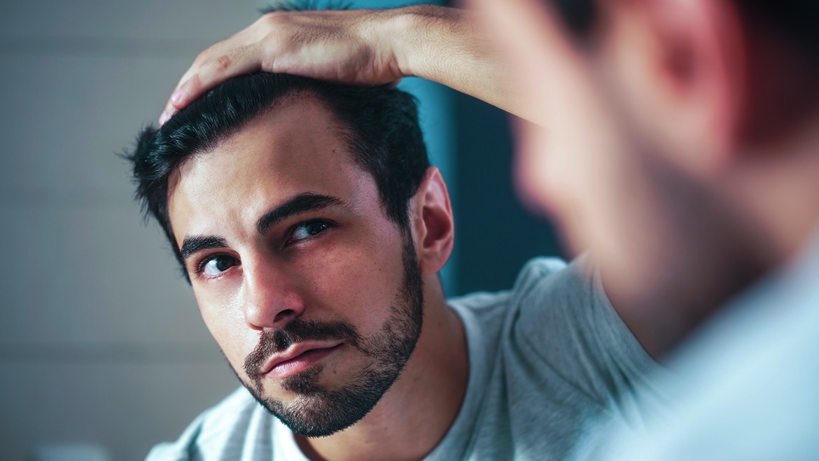 Man checking hairline in mirror Text