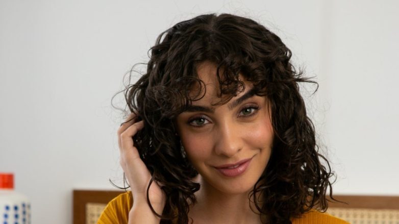 modelo de cabelo cacheado após a técnica plopping