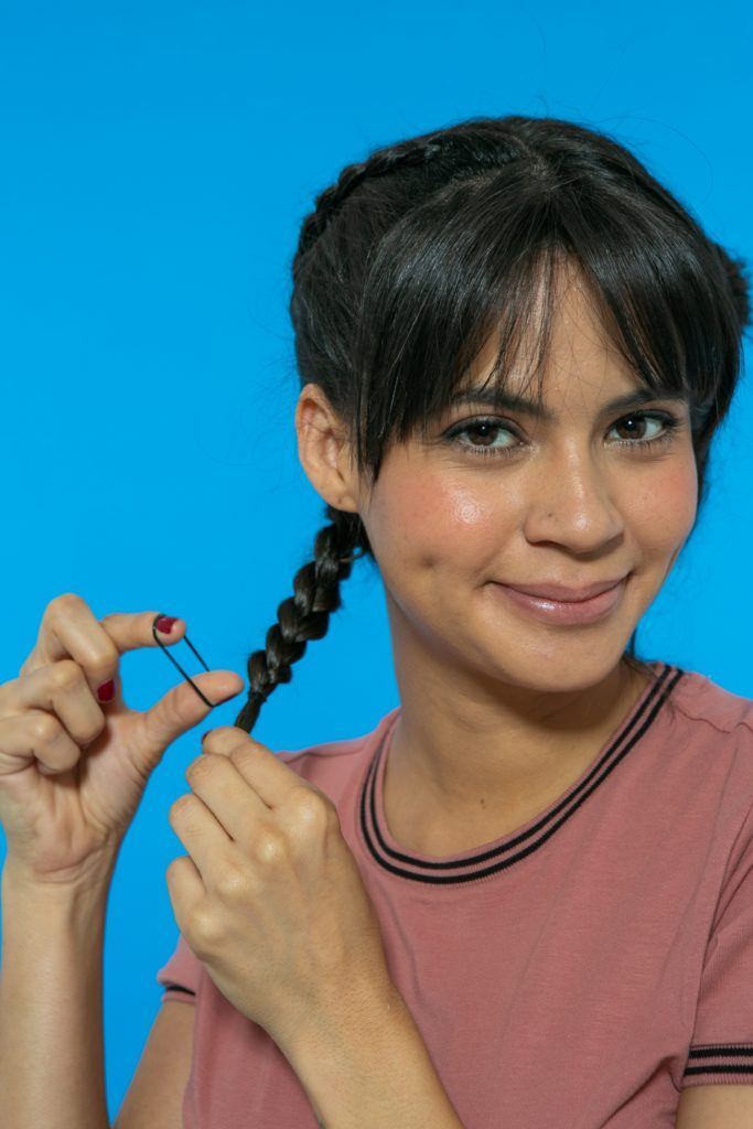 modelo prendendo a trança simples com um elástico de cabelo