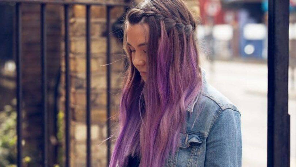 Mulher com cabelos violeta e trança tiara na franja