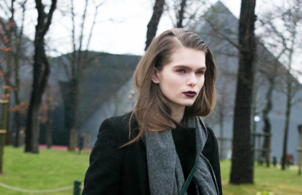 Mulher usa gel na franja partida de lado e batom escuro