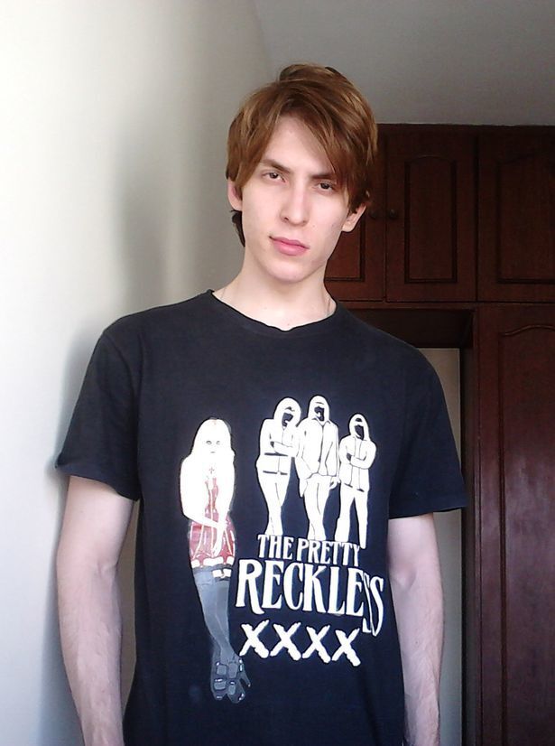 rapaz de camiseta preta e cabelos curtos posa olhando para a câmera
