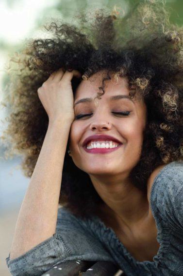 modelo com cabelo crespo ilustrando a matéria sobre touca de cetim para cabelo cacheado