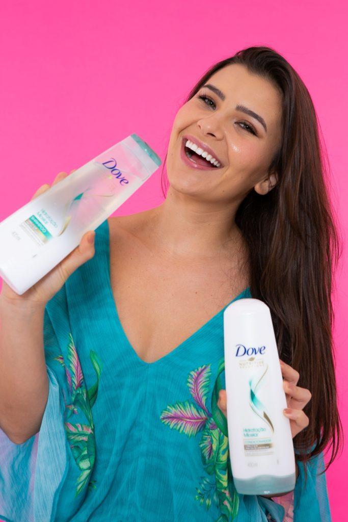 Modelo segurando o Shampoo e o Condicionador Dove Hidratação Intensa Com Infusão de Oxigênio