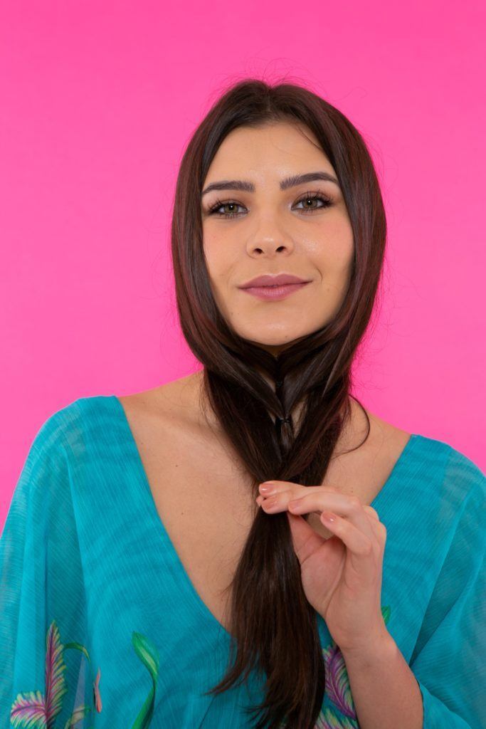 modelo separando o cabelo em mechas finas e prendendo com elástico