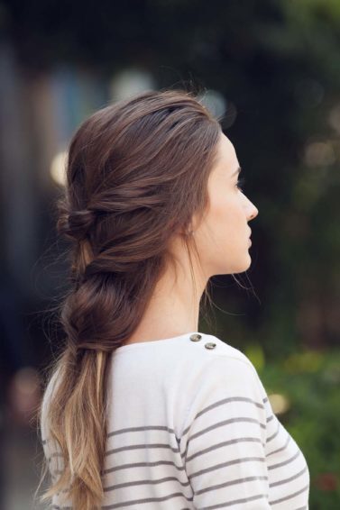 mulher posa, ao ar livre, usando trança francesa falsa