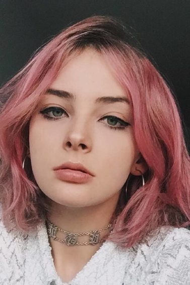 Mulher com cabelos lisos curtos e cor-de-rosa