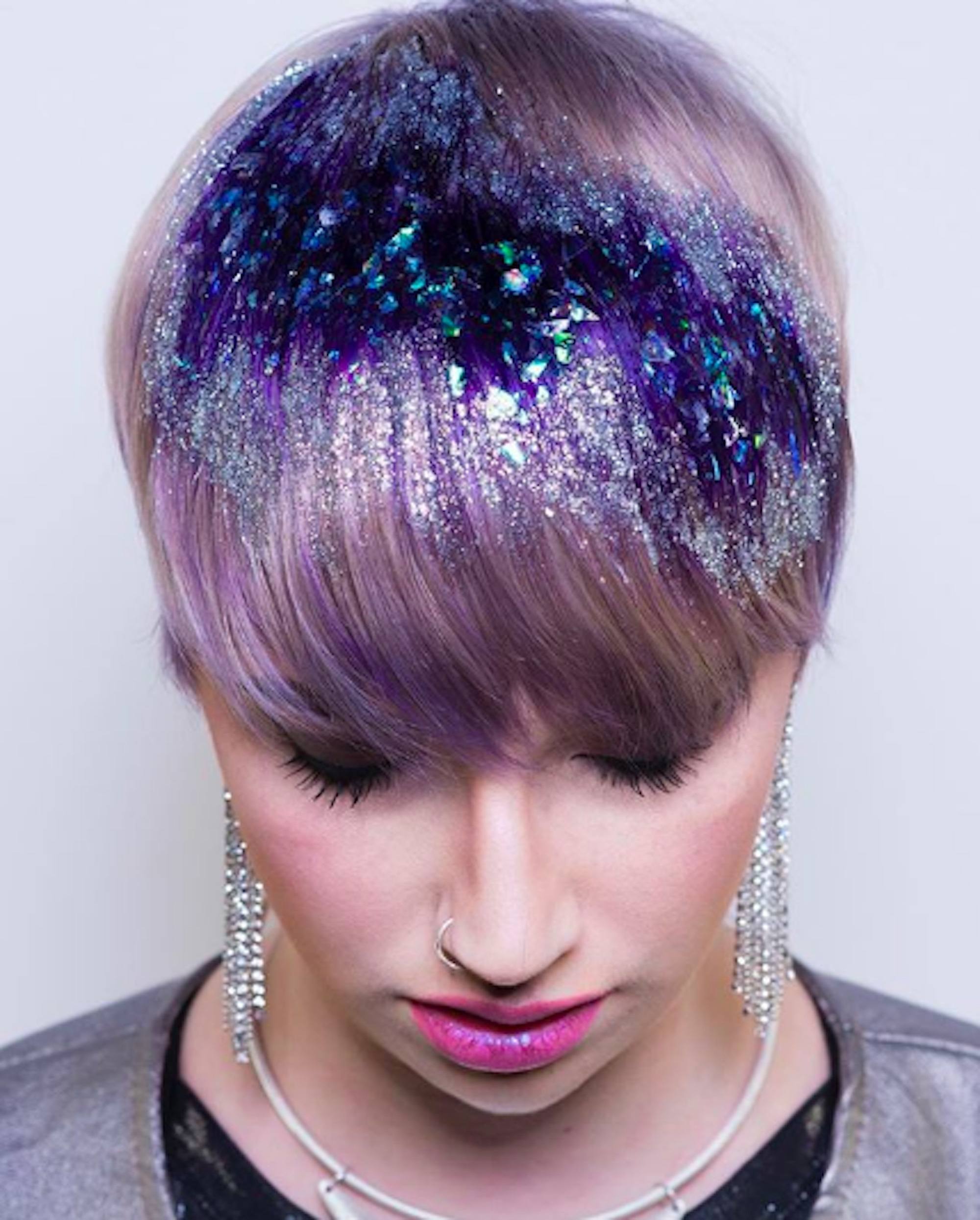 Mulher com cabelos curtos lilás e glitter na franja