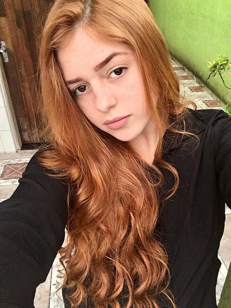 Mulher com cabelos ruivos longos e ondulados