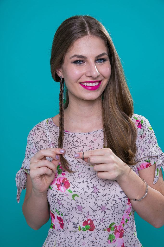 Mulher com cabelos castanho-claro longos fazendo trança tiara