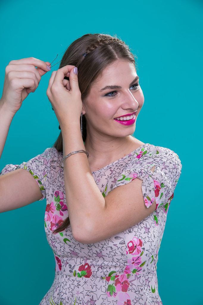 Mulher com cabelos castanho-claro longos fazendo trança tiara