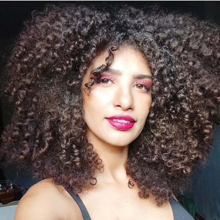 mulher com cabelo cacheado longo castanho