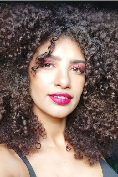 duas mulheres sorrindo com cabelo cacheado