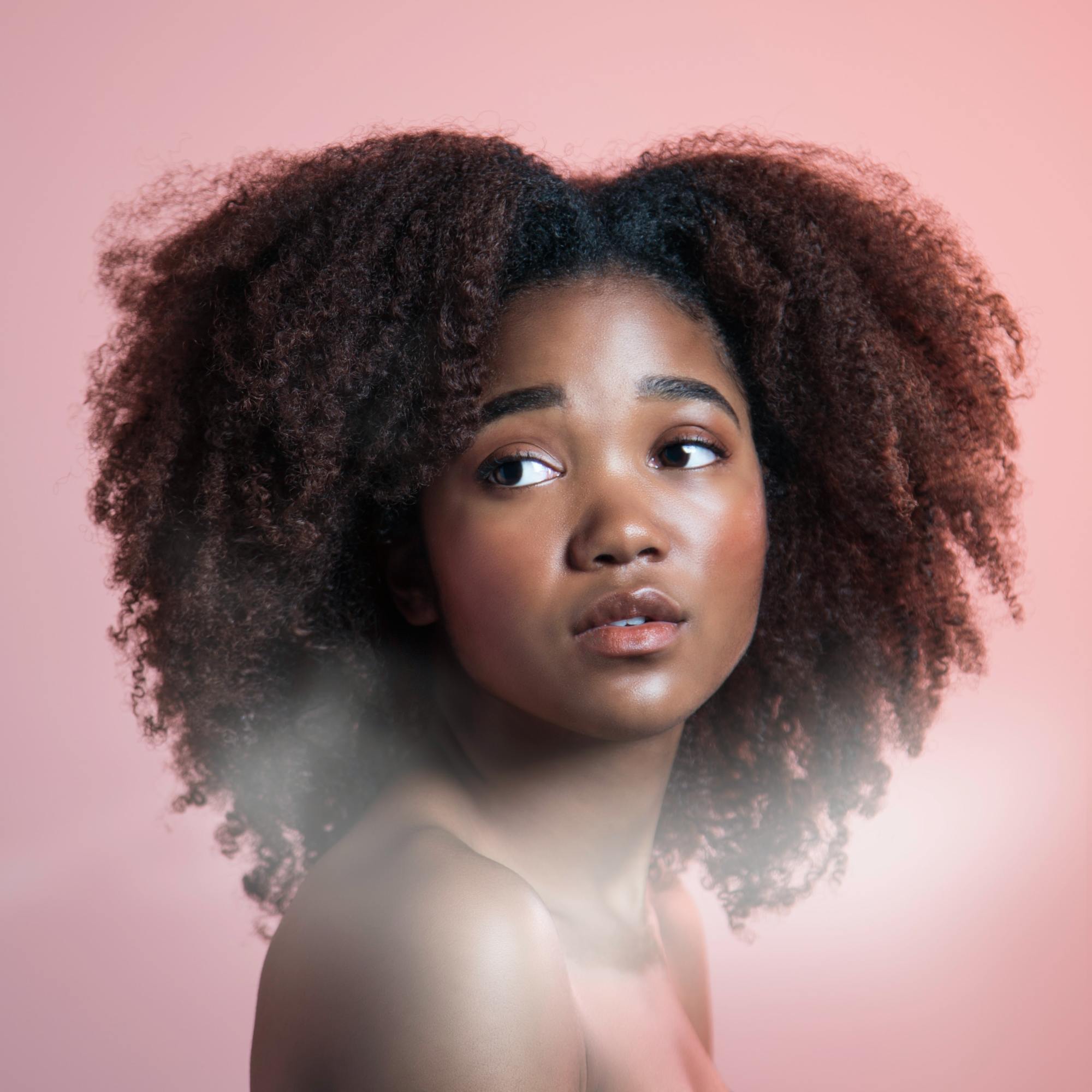 mulher com cabelo crespo em corte coração
