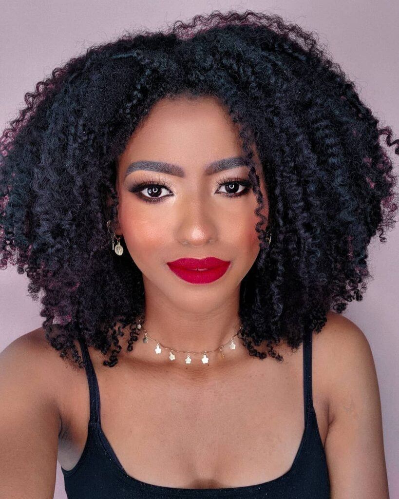 Mulher com cabelo cacheado long bob no rosto triangular