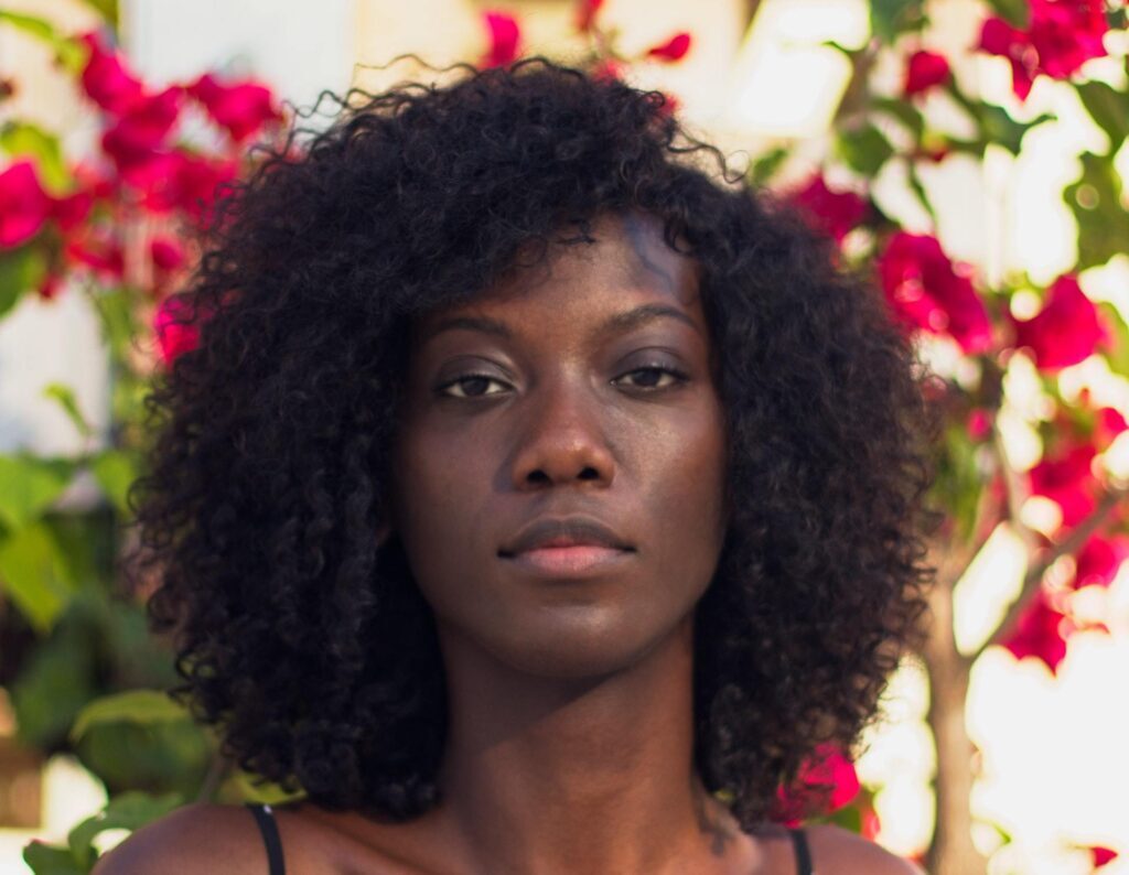 Mulher de cabelo cacheado preto e rosto quadrado