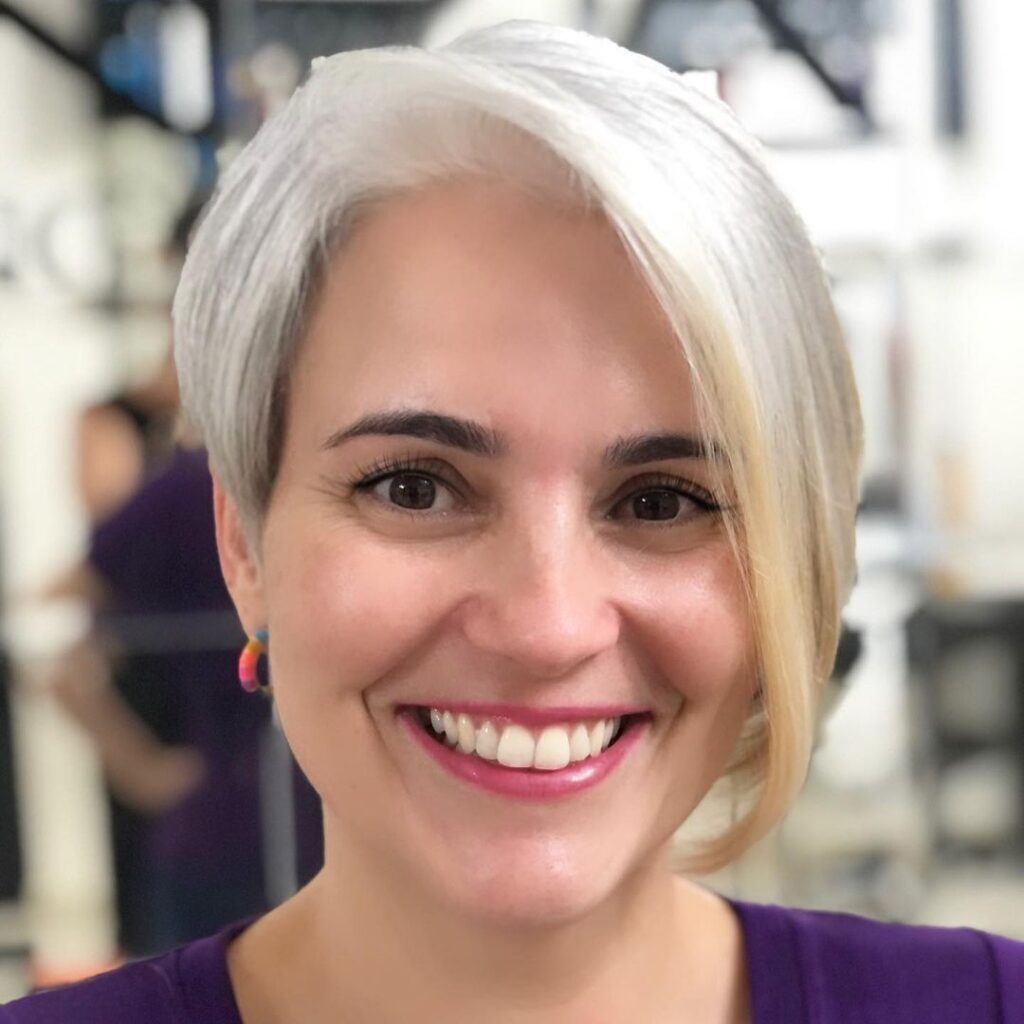 mulher sorrindo com cabelo platinado e franja longa liso