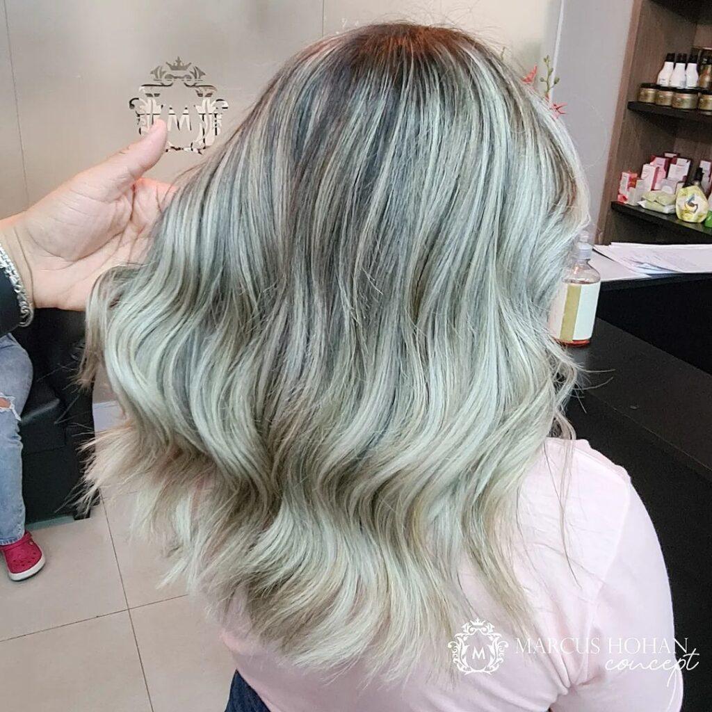 mulher de lado mostrando o cabelo loiro com raiz esfumada platinado médio