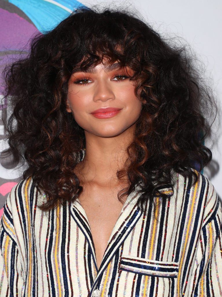 atriz zendaya com corte long bob com franja em cabelo cacheado