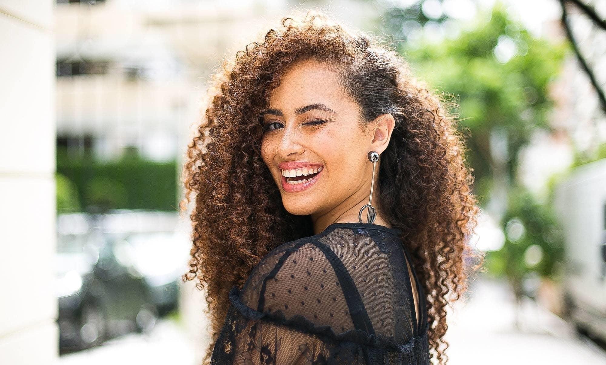 Modelo com cabelo cacheado na lateral castanho
