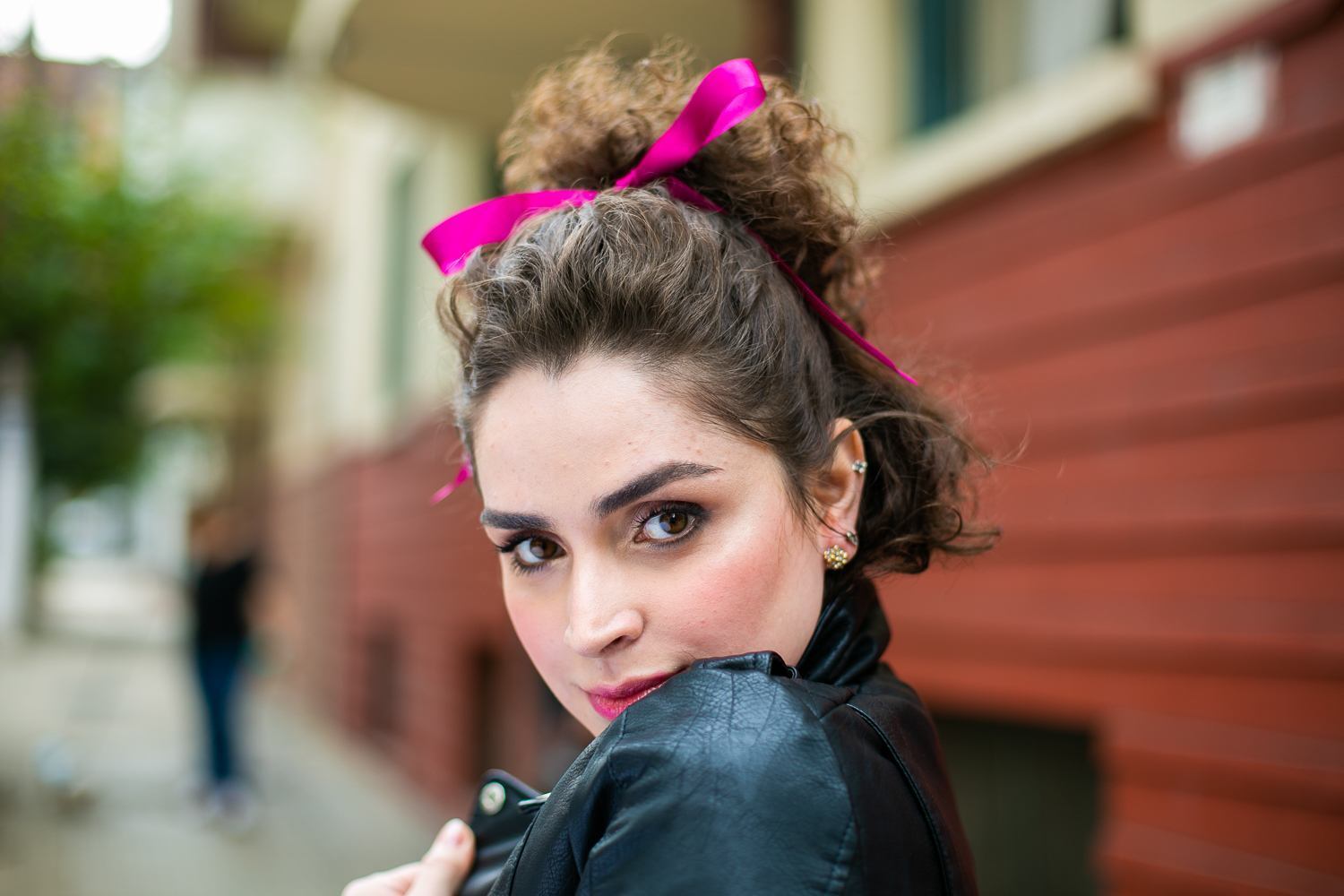 Modelo com cabelo semipreso curto castanho com laço rosa