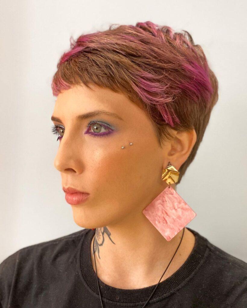 mulher de lado mostra o cabelo pixie rosa
